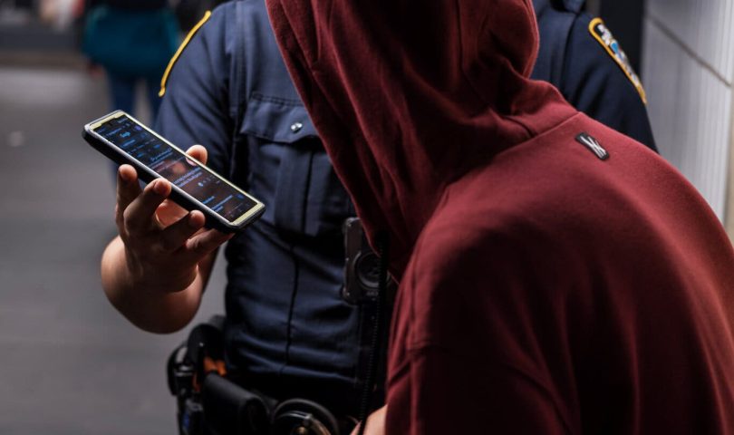Photo of cop accosting an unhoused person. Photo by Gus Aronson | The New York Times