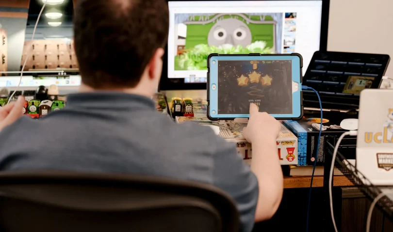 Woody Brown at his desk with carefully arranged “Thomas & Friends” trains and various screens and tablets. Photo by Peyton Fulford | The New York Times