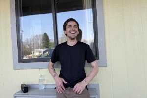 George Langley poses in front of his emergency shelter provided by Hotels for Homeless on March 26 in Bloomington. Photo by Emerson Elledge / The Indiana Daily Student